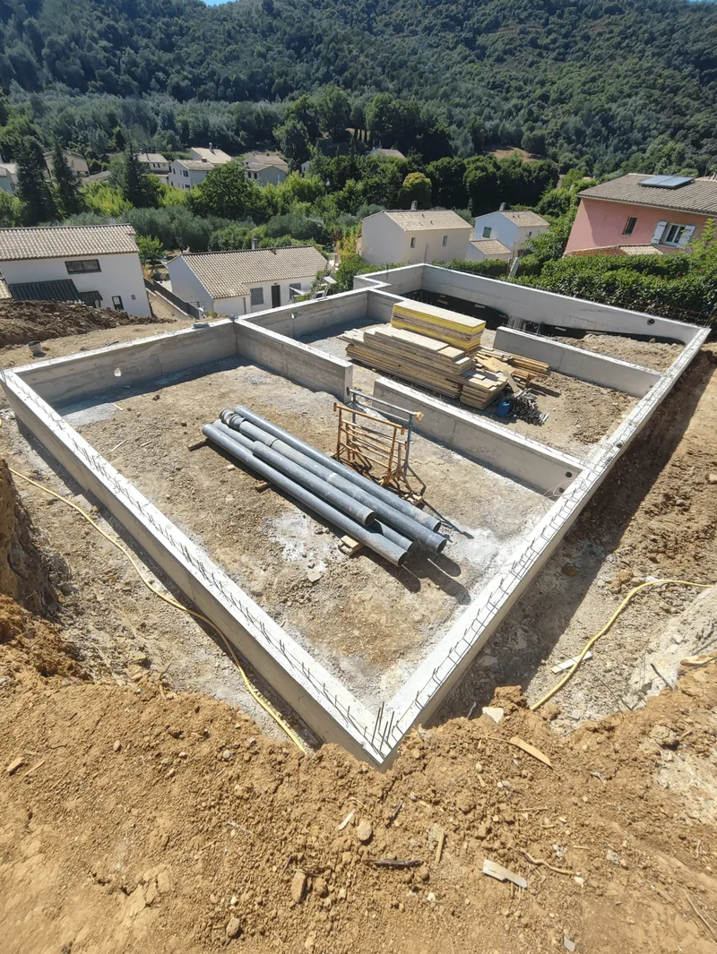 Fondations en béton et soubassements sur un terrain excavé.