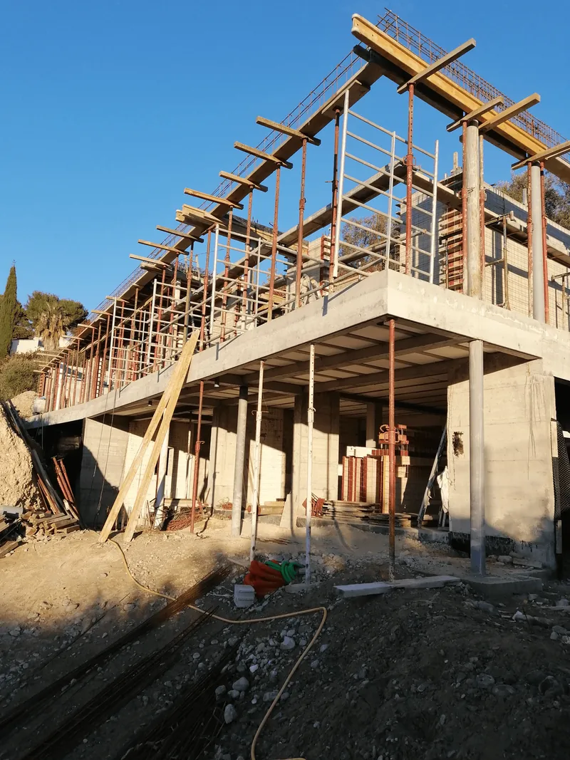 Structure de bâtiment en béton avec poteaux, plancher, coffrages et étais.